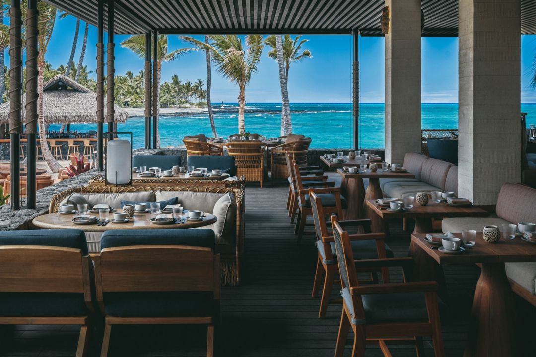 Open-air oceanfront restaurant with natural wood decor, offering fine dining with panoramic views of turquoise waters.